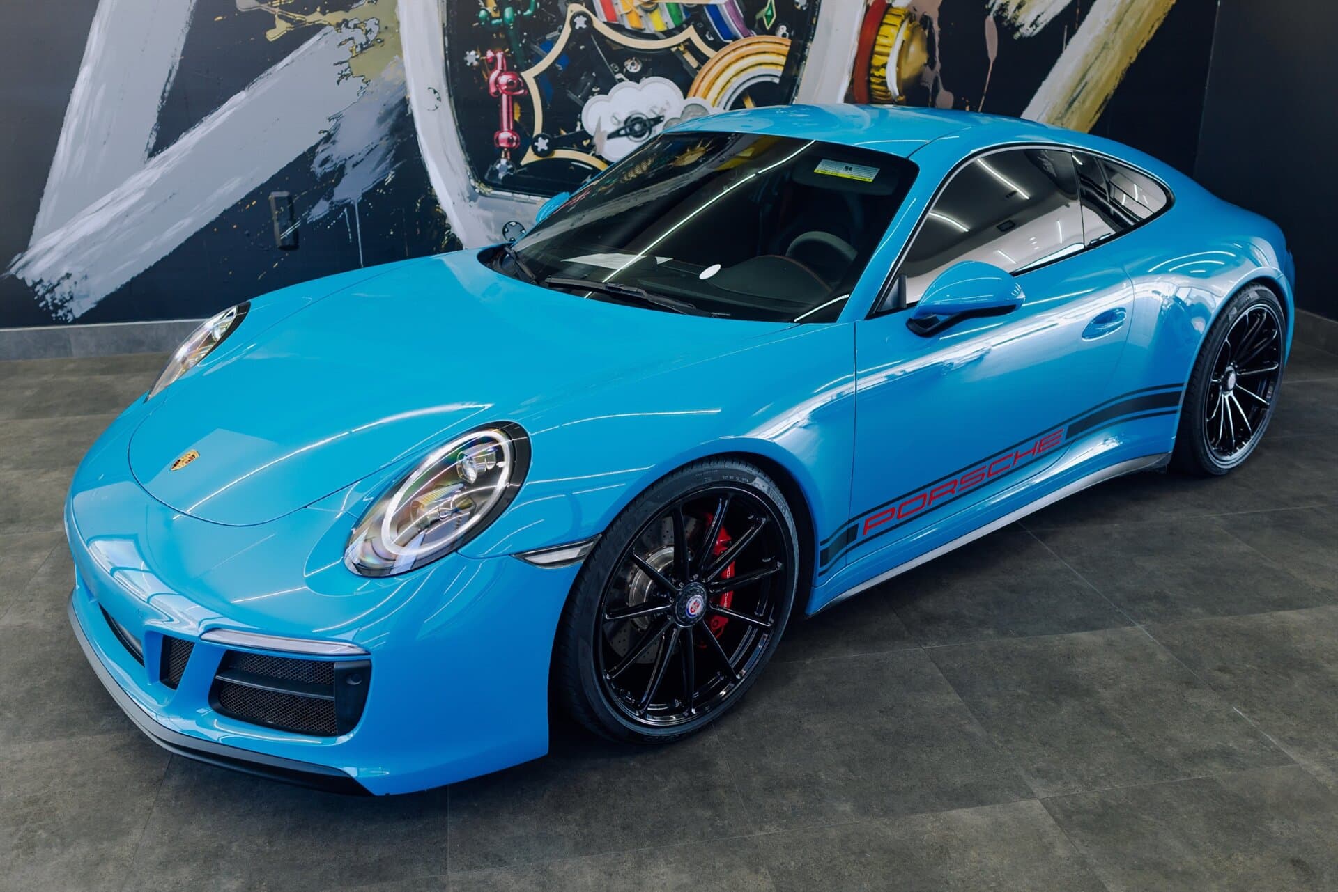 Blue Porsche 911 in a dealership showroom
